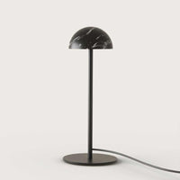 Tischleuchte Dussa von Aromas del Campo mit schwarzem Marmor‑Schirm und matt schwarzem Metallfuß.