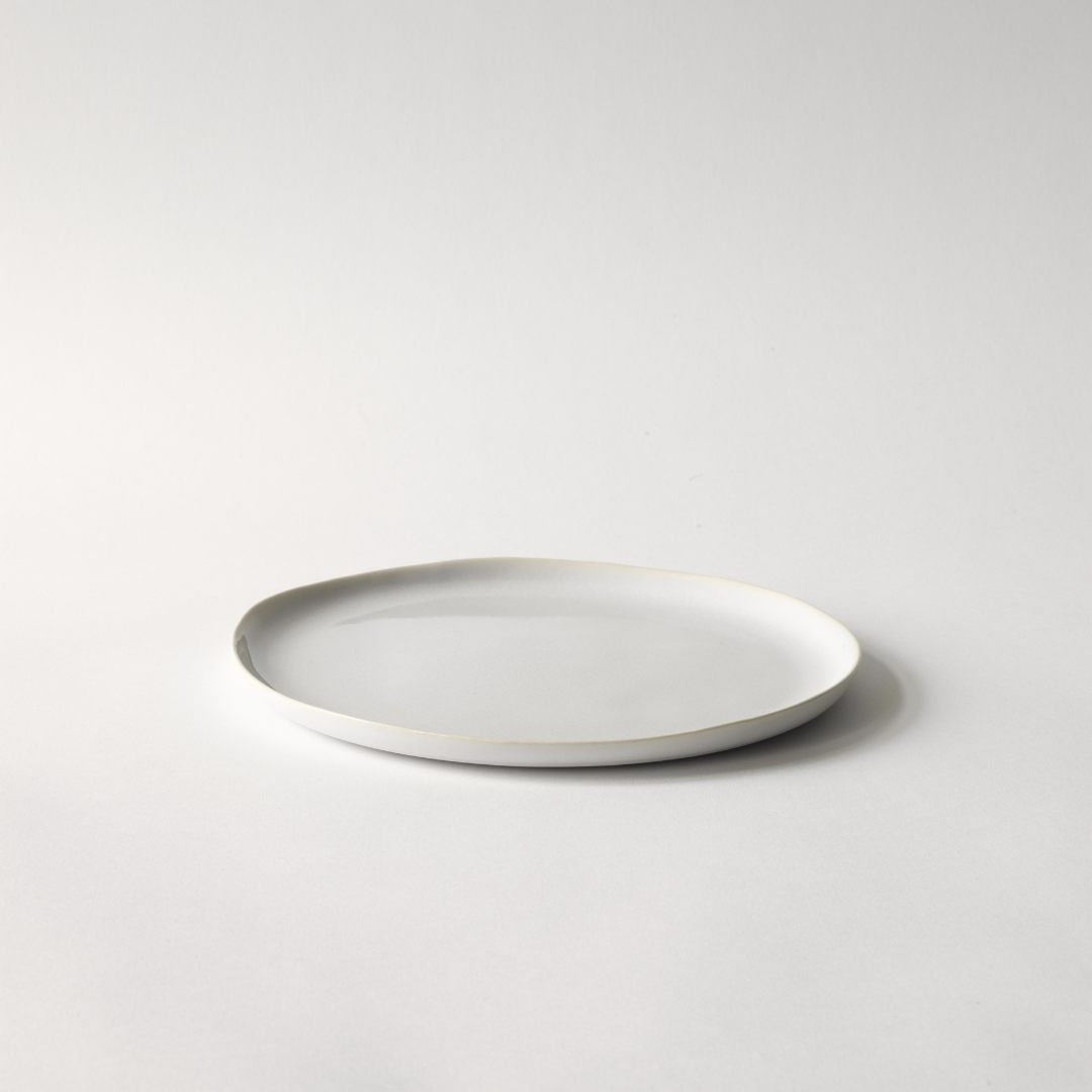 Set aus zwei flachen Tellern Vince von Tell Me More, handgefertigt aus weißem Steingut, glänzende Oberfläche, perfekt für Salate, Vorspeisen oder Kuchen.