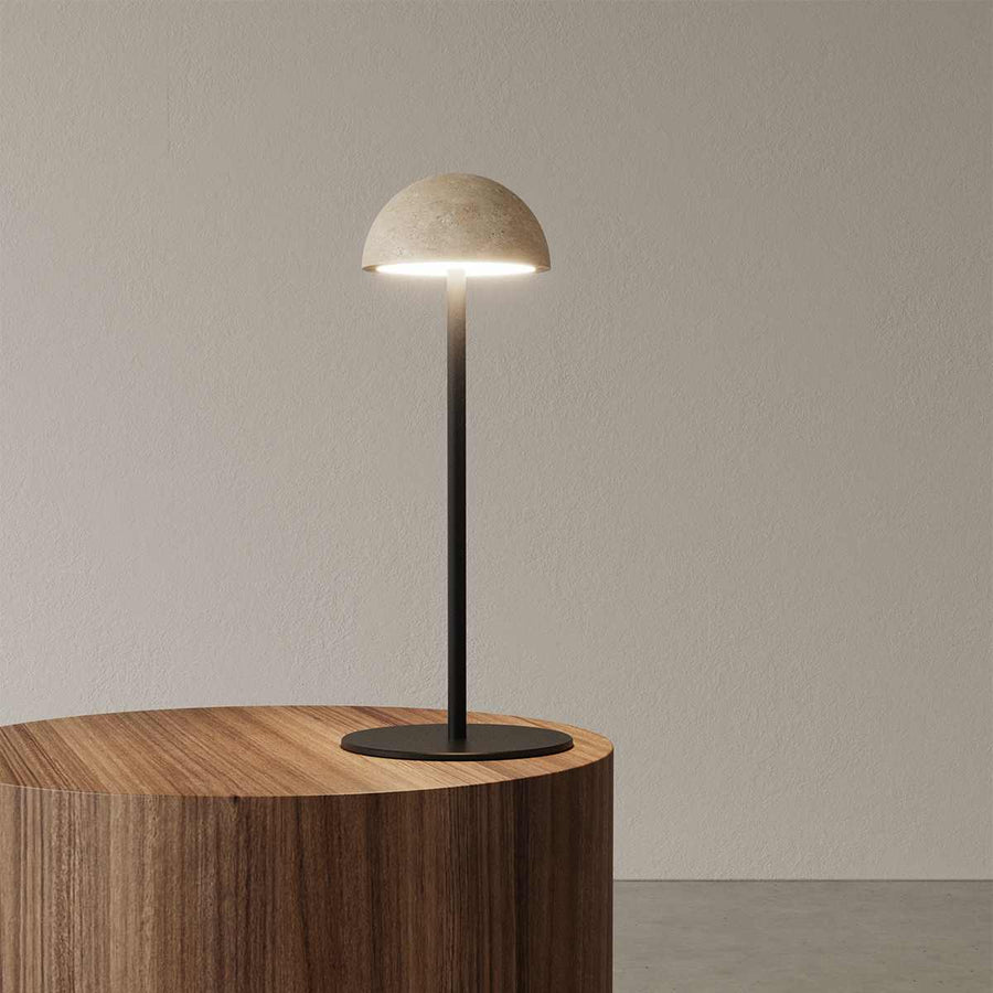 Tischleuchte Dussa von Aromas del Campo mit hellem Travertin‑Schirm und matt schwarzem Metallfuß