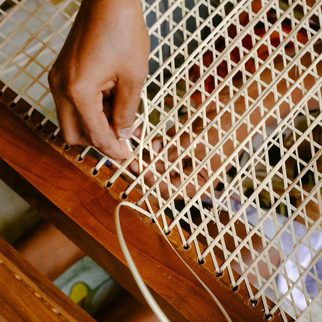 Leuchtenschirm 'Nymo' von Cane Cult aus geflochtenem Seegras in Naturfarben, boho-skandinavischer Stil, Nahaufnahme der handwerklichen Flechtarbeit mit Hand eines Handwerkers