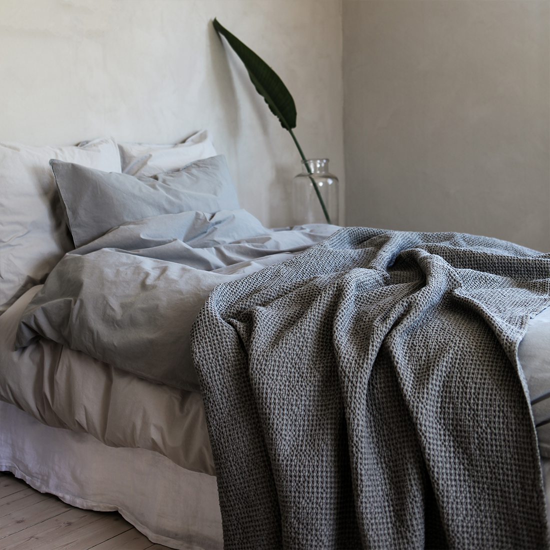 Kissenbezüge 'Frost' im Detail – hochwertige Verarbeitung mit sauberem Wickelverschluss und feiner Baumwollqualität auf einem Bett arrangiert mit einer Tagesdecke als Überwurf