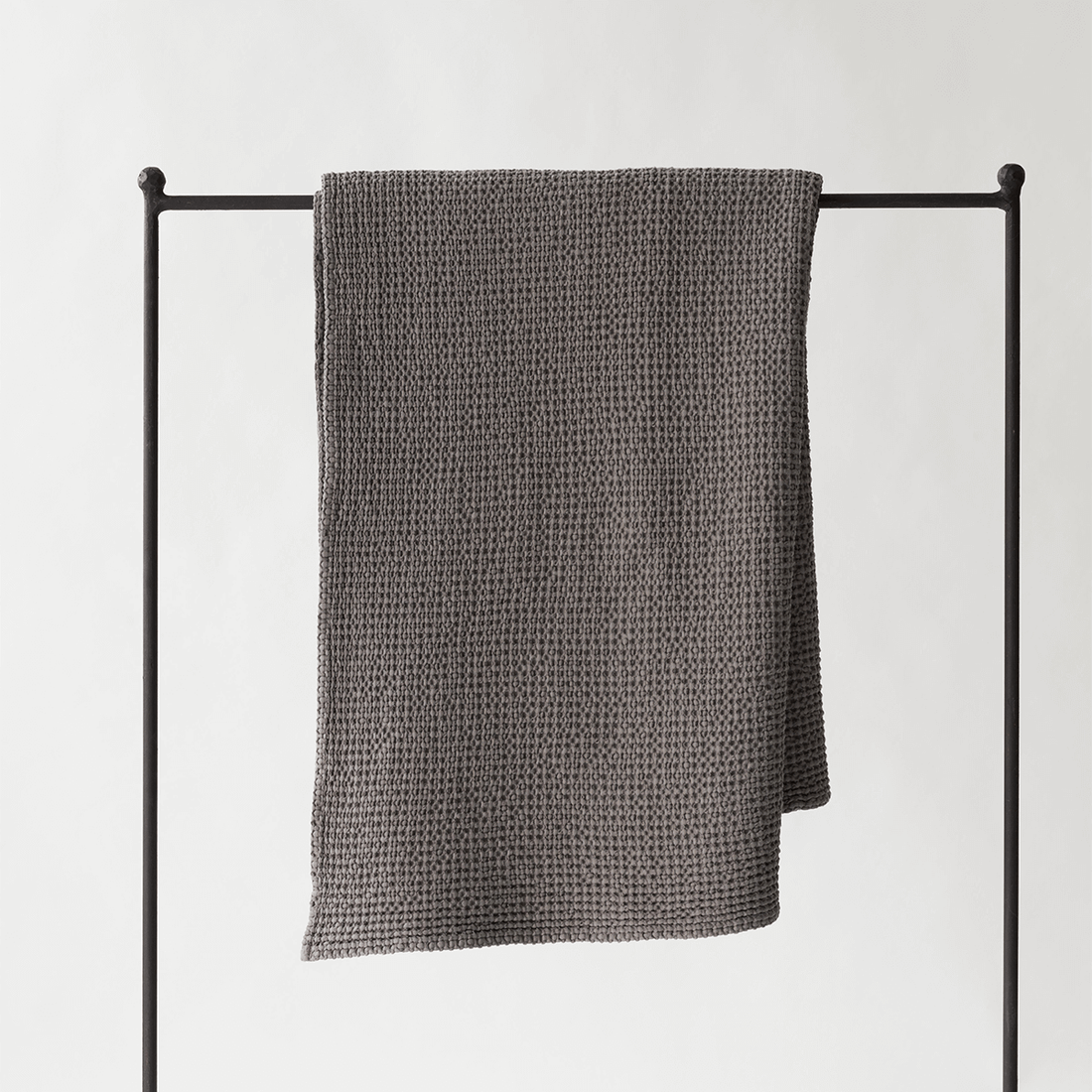 Decke 'Miro' dunkelgrau 140×200 cm von Tell Me More – Waffelpiqué-Decke gerade über schwarzen Kleiderständer gehängt, 100% Baumwolle hergestellt in Portugal, Detailansicht Textur